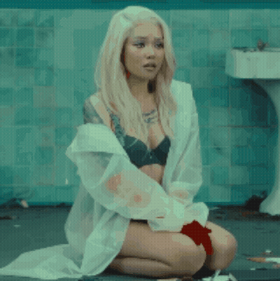 A Woman Is Kneeling Down In A Bathroom With Blood On Her Clothes GIF