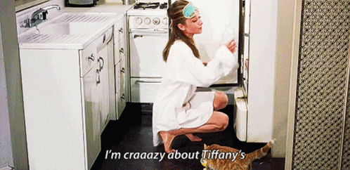 A Woman Is Kneeling Down In A Kitchen With A Cat And Says I 'M Craaazy About Tiffany ' GIF