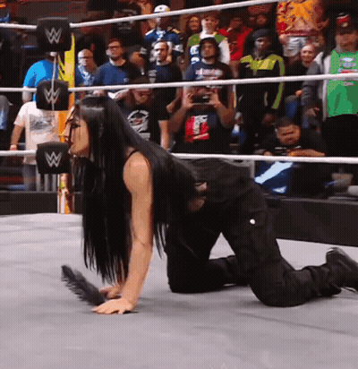 A Woman Is Kneeling Down In A Wrestling Ring With A W Logo On The Ropes GIF