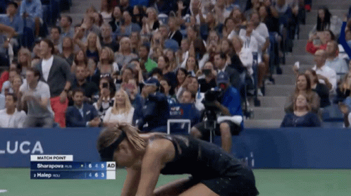 A Woman Is Kneeling Down In Front Of A Crowd At A Us Open Match GIF