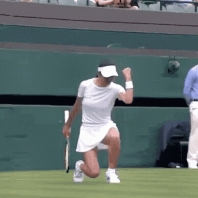 A Woman Is Kneeling Down On A Tennis Court With A Tennis Racket . GIF