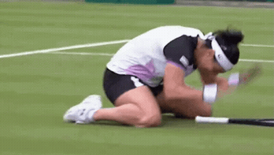 A Woman Is Kneeling Down On A Tennis Court With Her Head On A Tennis Racquet GIF