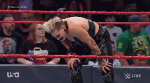 A Woman Is Kneeling In A Wrestling Ring During A Women 'S Title Match .. GIF