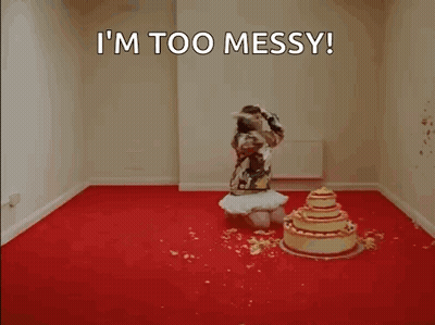 A Woman Is Kneeling In Front Of A Cake In A Room . GIF