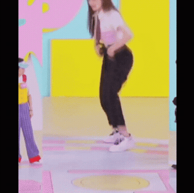 A Woman Is Kneeling On The Floor While Wearing Headphones And Dancing . GIF