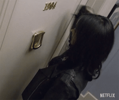 A Woman Is Knocking On A Door That Has The Number 1904 On It GIF