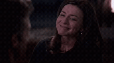 A Woman Is Laughing And Looking Up At Something In The Dark . GIF