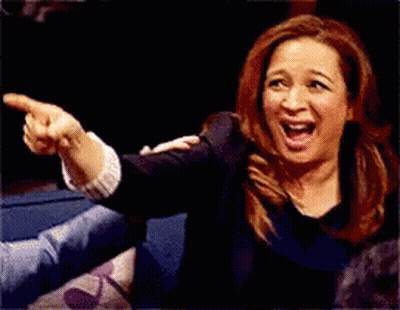 A Woman Is Laughing And Pointing At Something With Her Finger GIF