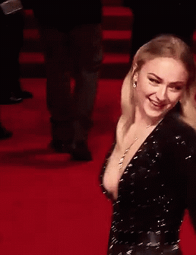 A Woman Is Laughing On A Red Carpet With Her Mouth Open GIF