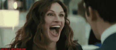 A Woman Is Laughing While Looking At A Man With Her Tongue Sticking Out GIF