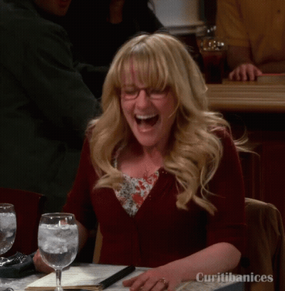 A Woman Is Laughing While Sitting At A Table With Curitibanices Written On It GIF