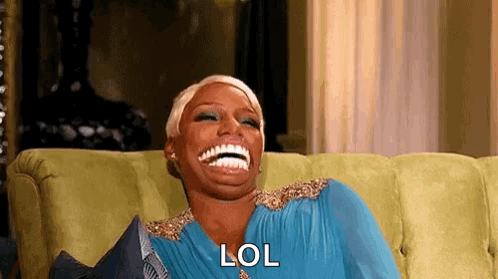A Woman Is Laughing While Sitting On A Couch And Saying Lol . GIF