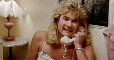 A Woman Is Laughing While Talking On A Phone . GIF