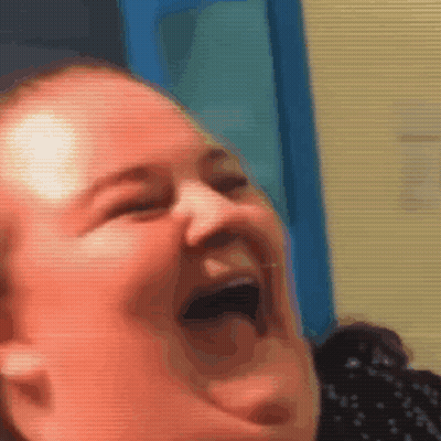 A Woman Is Laughing With Her Mouth Open And Her Tongue Out . GIF