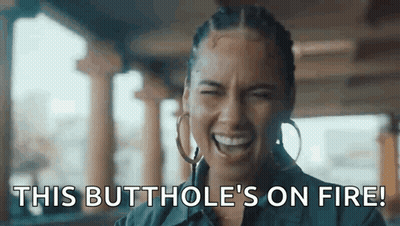 A Woman Is Laughing With The Words `` This Butthole 'S On Fire '' Written On Her Face . GIF