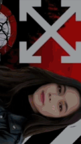 A Woman Is Laying Down In Front Of A White X On A Red And Black Background GIF
