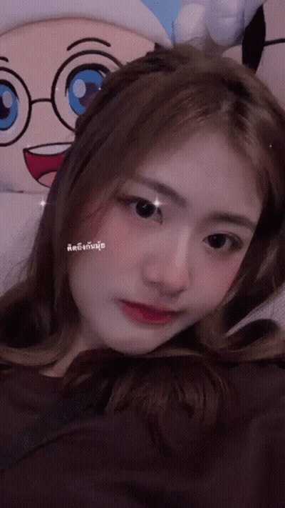 A Woman Is Laying Down With A Stuffed Animal In The Background GIF