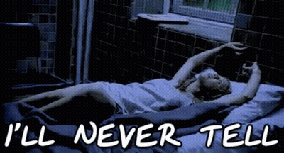 A Woman Is Laying In A Bed With The Words " I 'Ll Never Tell " On The Bottom GIF