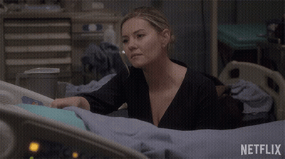 A Woman Is Laying In A Hospital Bed With A Netflix Logo Behind Her GIF