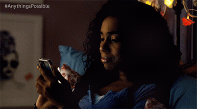 A Woman Is Laying In Bed Looking At Her Phone With The Hashtag Anythings Possible GIF