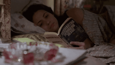 A Woman Is Laying In Bed Reading A Book By Samantha Hermann Hessen GIF