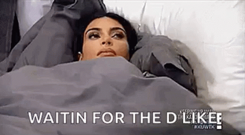 A Woman Is Laying In Bed Under A Blanket And Waiting For A Date . GIF