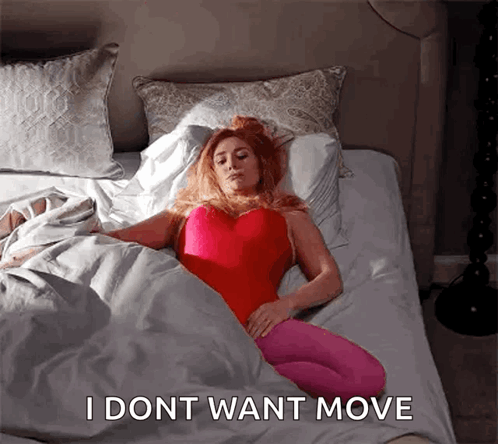 A Woman Is Laying In Bed With The Words I Dont Want Move Written On The Bottom GIF