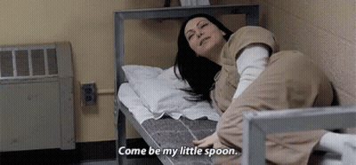 A Woman Is Laying On A Bed In A Prison Cell And Says `` Come Be My Little Spoon '' . GIF