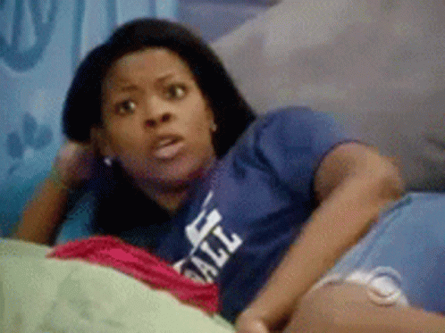 A Woman Is Laying On A Bed Wearing A Blue Shirt That Says All GIF