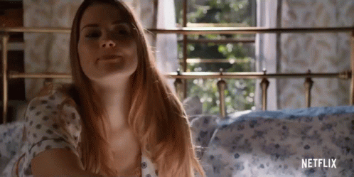 A Woman Is Laying On A Bed With A Netflix Logo On The Bottom GIF