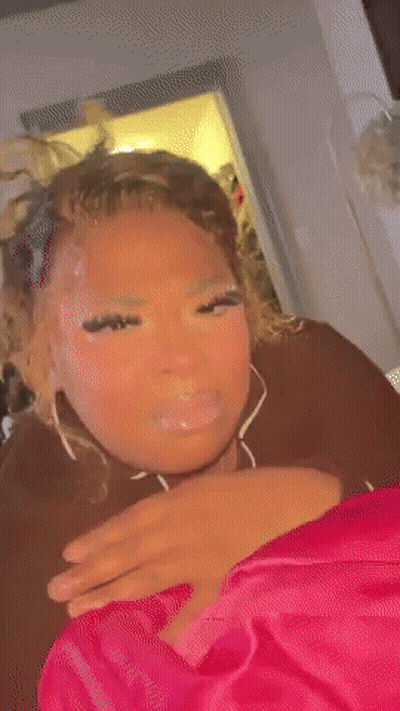 A Woman Is Laying On A Bed With Her Eyes Closed And Making A Funny Face . GIF