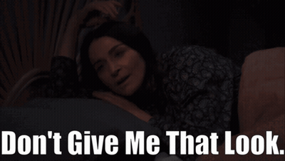 A Woman Is Laying On A Bed With The Words " Don 'T Give Me That Look " Below Her GIF