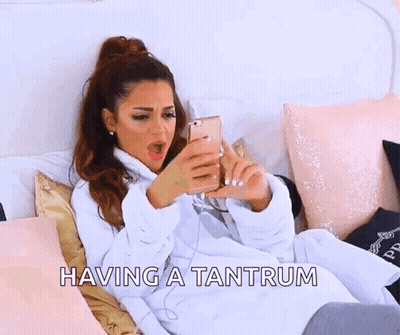 A Woman Is Laying On A Bed With The Words Having A Tantrum Written Above Her . GIF