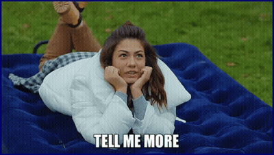 A Woman Is Laying On A Blue Mattress With The Words Tell Me More Written Below Her GIF