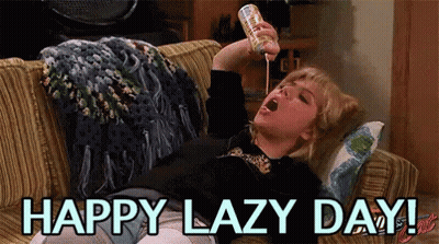 A Woman Is Laying On A Couch Drinking From A Can And The Words Happy Lazy Day Are Above Her GIF