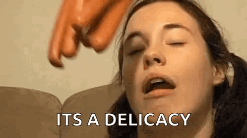 A Woman Is Laying On A Couch With Her Eyes Closed And A Hand Reaching For Her Face . GIF