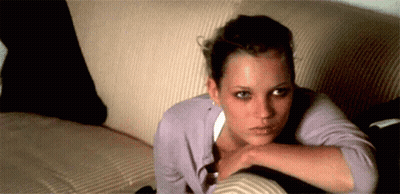 A Woman Is Laying On A Couch With Her Head Resting On Her Arm GIF