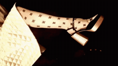 A Woman Is Laying On A Couch With Her Legs Crossed And Wearing Polka Dot Tights . GIF