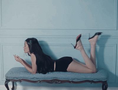 A Woman Is Laying On Her Stomach On A Bench And Looking At Her Phone GIF