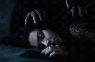 A Woman Is Laying On The Floor With Her Hands On Her Head . GIF