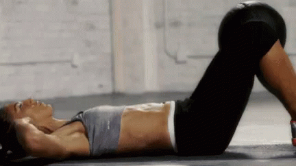 A Woman Is Laying On The Floor With Her Legs Crossed And A Reebok Top On GIF
