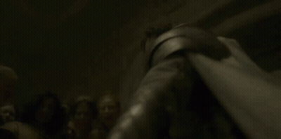 A Woman Is Laying On The Ground With A Knife In Her Hand And A Light Shining On Her Face . GIF