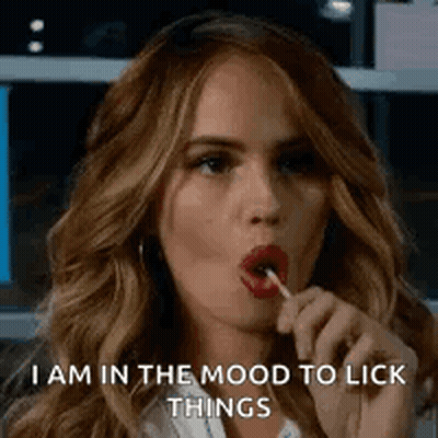 A Woman Is Licking A Lollipop In Her Mouth While Saying `` I Am In The Mood To Lick Things '' . GIF