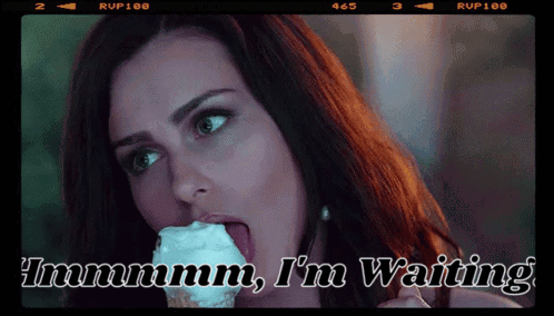A Woman Is Licking An Ice Cream Cone And The Caption Says " Immmm I 'M Waiting " GIF