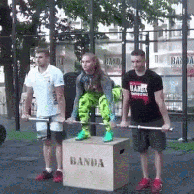 A Woman Is Lifting A Barbell On Top Of A Box That Says Banda . GIF