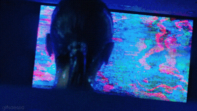 A Woman Is Looking At A Colorful Screen With The Words Gifsaespa On The Bottom Right GIF