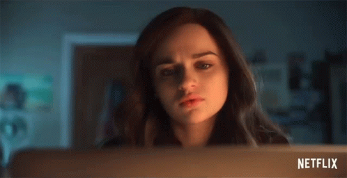 A Woman Is Looking At A Laptop Screen With A Netflix Logo In The Corner . GIF