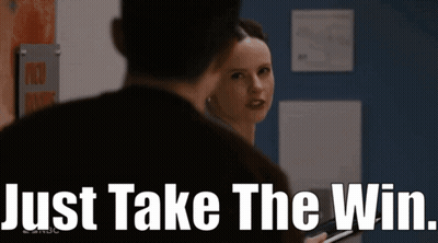 A Woman Is Looking At A Man With The Words Just Take The Win Behind Her GIF