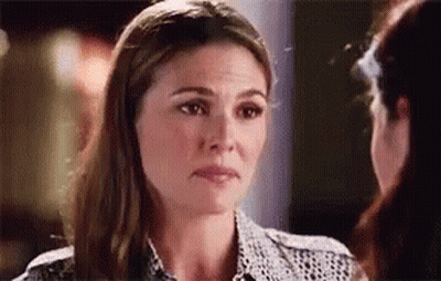 A Woman Is Looking At Another Woman 'S Face And Making A Funny Face . GIF