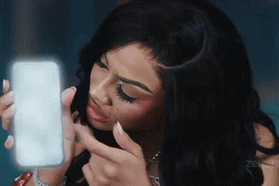 A Woman Is Looking At Herself In The Mirror GIF